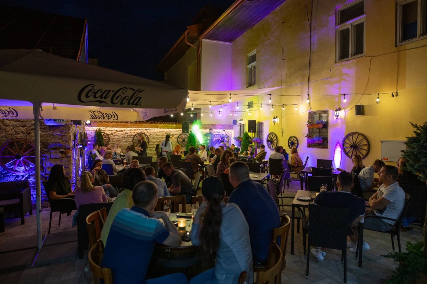 Letná terasa Kolkárne večer – plné stoly a živá hudba